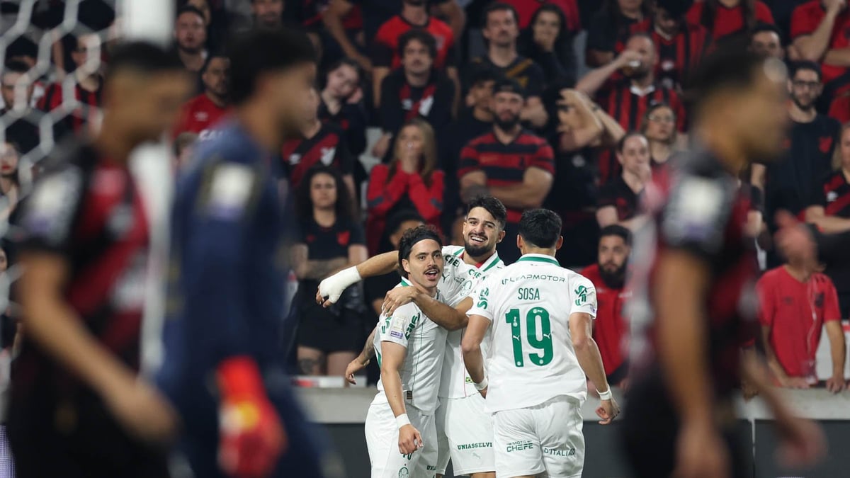 Jogadores do Palmeiras, de uniforme branco, comemoram gol contra o Athletico-PR na Arena da Baixada